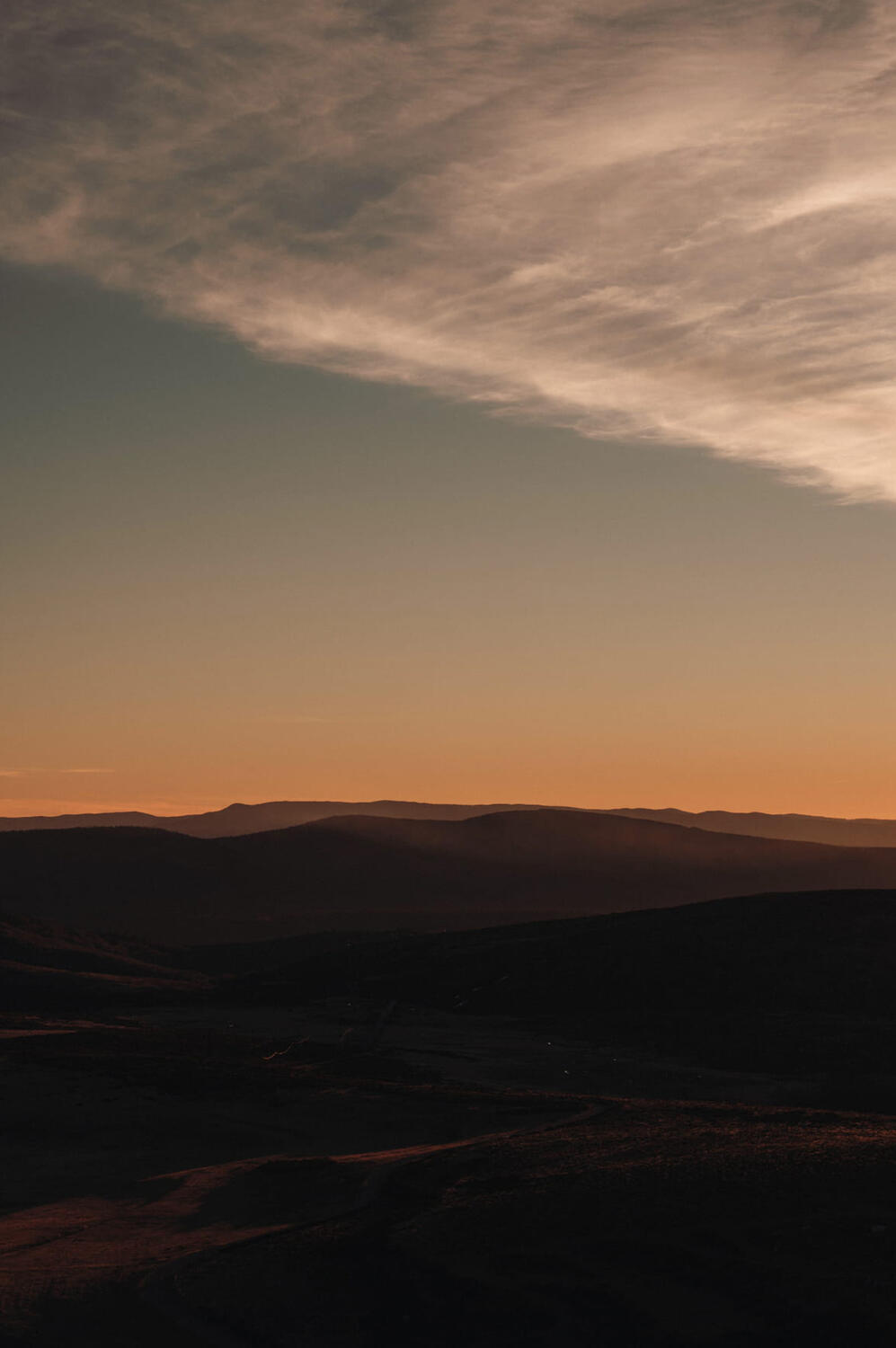 Orange and teal sunset on mountains